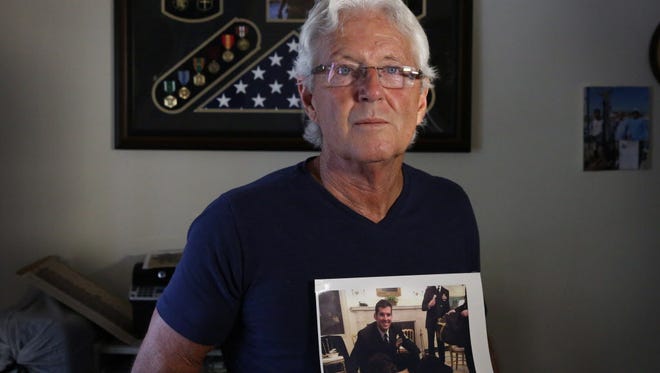 William Owens holds a photo of his son, Navy SEAL William "Ryan" Owens, in Lauderdale-By-the-Sea, Fla., in February 2017.