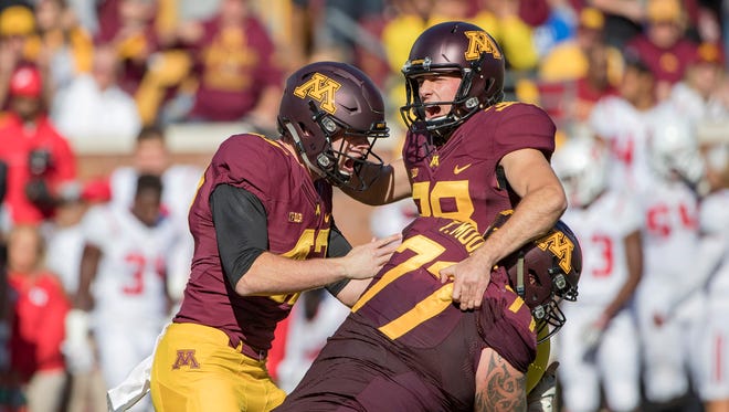 Minnesota Golden Gophers place kicker Emmit Carpenter (38) celebrates with punter Jacob Herbers (47) and offensive lineman Tyler Moore (77) after kicking a game winning field goal in the fourth quarter against the Rutgers Scarlet Knights at TCF Bank Stadium. The Gophers won 34-32.