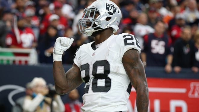 Oakland Raiders running back Latavius Murray (28) celebrates his first quarter touchdown against Houston Texans safety Quintin Demps (27) in the AFC Wild Card playoff football game at NRG Stadium.