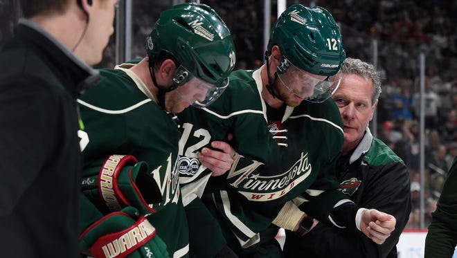 Minnesota Wild center Eric Staal is helped off the ice after crashing face-first into the boards.
