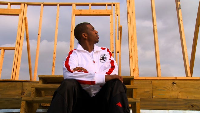 2008: Chris Paul of the New Orleans Hornets looks up at the framing of a home he helped build and raise for a family in partnership with Habitat for Humanity.