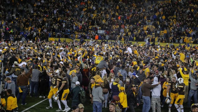 Wyoming fans rush the field after a win against Boise State.