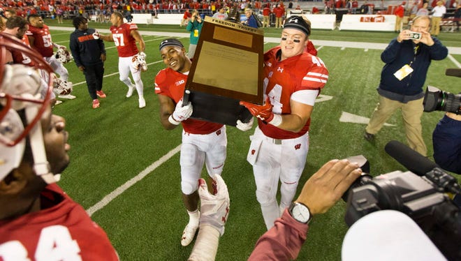 Wisconsin running back Corey Clement (6) and tight end Eric Steffes (44) lift the Freedom Trophy following the game against Nebraska.