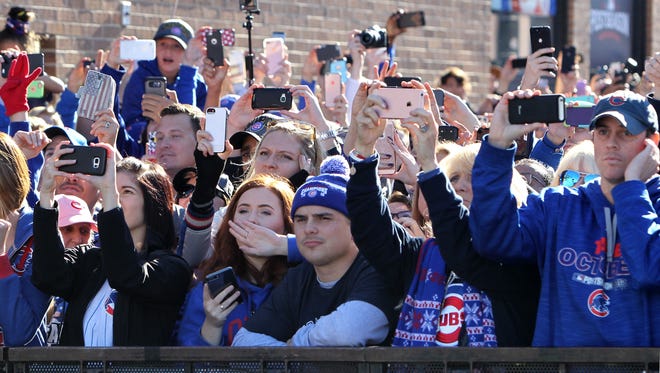 Fans take pictures of the parade.
