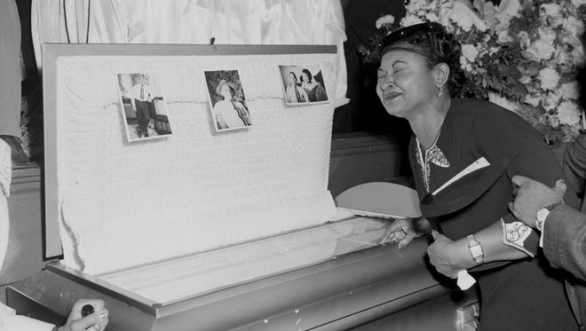 In this 1955 file photo, Mamie Mobley, mother of Emmett Till, pauses at her son's casket at a Chicago funeral home. The 14-year-old Chicagoan was killed in 1955 after reportedly whistling at a white woman during a visit to his uncle's house in Mississippi.