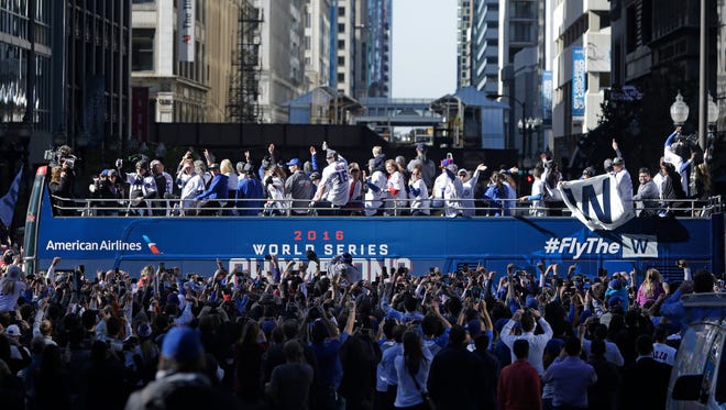 Cubs players wave to fans during the parade.