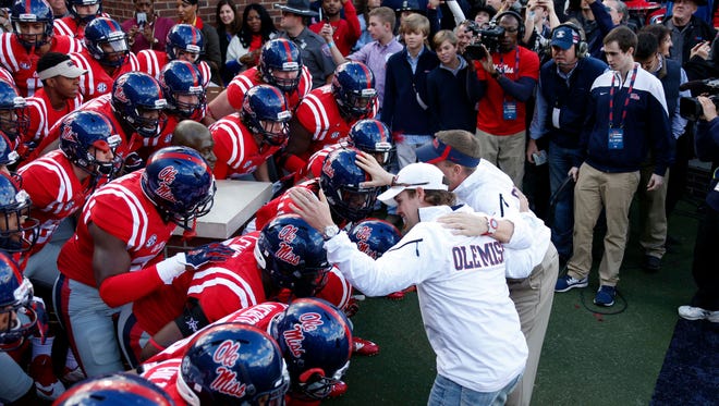 NASCAR driver Ricky Stenhouse Jr., left, joins Mississippi football coach Hugh Freeze in getting the team pumped up for their NCAA college football game against Mississippi State in Oxford, Miss., Saturday, Nov. 29, 2014. No. 18 Mississippi defeated No. 4 Mississippi State, 31-17. (AP Photo/Rogelio V. Solis)