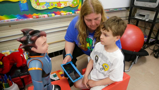 Logan Lucas, an eight-year-old 2nd grader at Shady Lane Elementary School student works with the robot Milo as Karen Richie, a Shady Lane Elementary School special education teacher observes.  Milo, the robot, helps children on the Autistic Spectrum Disorder learn better in the classroom. Shady Lane Elementary School in Menomonee Falls is one of the few schools that have access to such a tool that has improved social skills in children that were previously non-verbal and non-communicative.