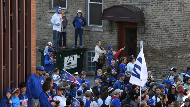 Fans celebrate during the parade outside of Wrigley Field on Addison Street.