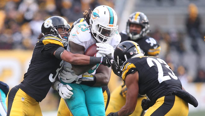 Miami Dolphins running back Jay Ajayi (23) carries the ball against the Pittsburgh Steelers during the first half in the AFC Wild Card playoff football game at Heinz Field.