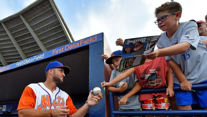 July 18: Tim Tebow signs autographs for fans.