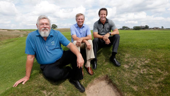 The three architects of Erin Hills, from left, Ron Whitten, Michael Hurdzan and Dana Fry, sit next to a bunker on the ninth hole of the golf course.