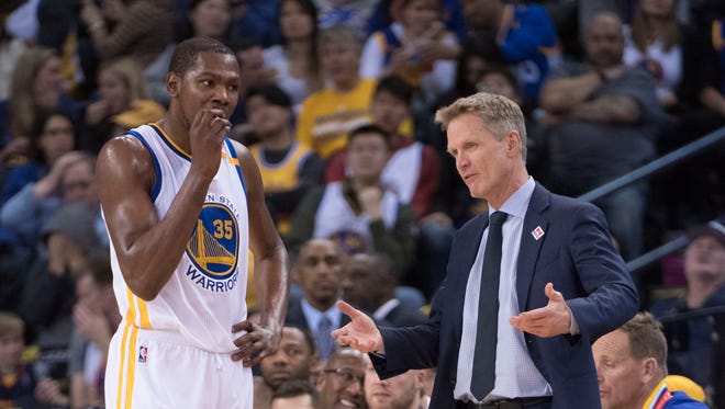 Warriors coach Steve Kerr (right) instructs forward Kevin Durant (35) during a regular-season game at Oracle Arena.