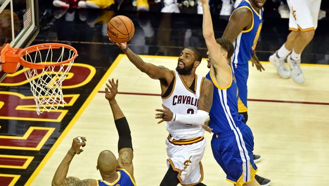 Cleveland Cavaliers guard Kyrie Irving (2) shoots the ball against Golden State Warriors forward David West (3) during the second quarter in game four of the Finals for the 2017 NBA Playoffs at Quicken Loans Arena.