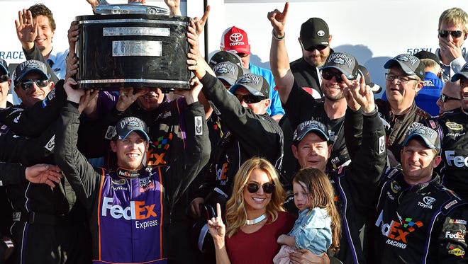 Hamlin hoists the Harley J. Early Trophy in victory lane with his team, girlfriend and daughter after winning the 2016 Daytona 500.