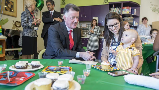 Jim Judge, Chairman, President and CEO of Eversource, left, decorates cupcakes with Catherine and mom at Boston Children's Hospital on June 7, 2017 in Boston, Massachusetts.