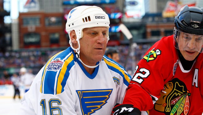 Former St. Louis Blues forward Brett Hull, left, battles along the board with former Chicago Blackhawks forward Grant Mulvey during the winter classic alumni outdoor game at Busch Stadium.