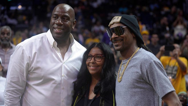 2017: Magic Johnson and wife Cookie pose for a photo with recording artist Snoop Dogg.