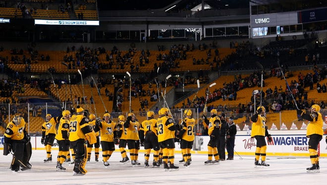 The Pittsburgh Penguins wave to their fans before leaving the ice after defeating the Philadelphia Flyers, 4-2, at Heinz Field.
