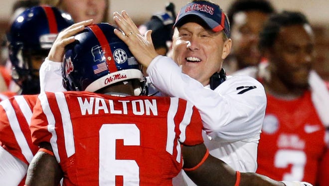 Mississippi head coach Hugh Freeze celebrates with running back Jaylen Walton (6) after Walton's 91-yard running touchdown during the second half of an NCAA college football game against Mississippi State in Oxford, Miss., Saturday, Nov. 29, 2014. No. 18 Mississippi beat No. 4 Mississippi State 31-17. (AP Photo/Rogelio V. Solis)