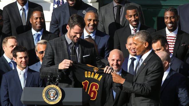 President Barack Obama is presented a jersey by Cleveland Cavaliers forward Kevin Love at an event honoring the 2016 NBA world champion Cavaliers on the South Lawn at the White House.
