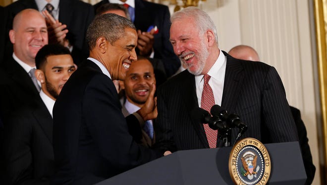 President Barack Obama shakes hands with San Antonio Spurs head coach Gregg Popovich during a ceremony honoring the NBA champion Spurs in the East Room at The White House.
