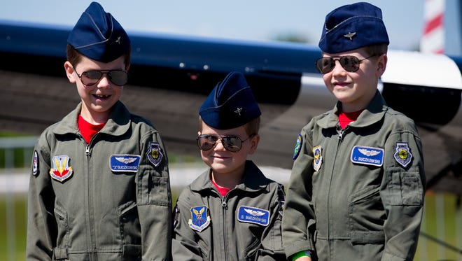Seven-year old Xavier, left, and his brothers Dominic and Luke pose for a photo in front of a vintage airplane at the annual Paine Field Aviation Day in Everett, Wash., on May 20, 2017.