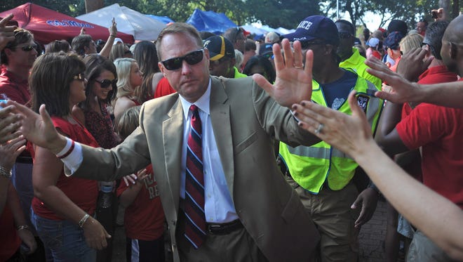 Mississippi coach Hugh Freeze greets fans as the team walks through the Grove before an NCAA college football game against Missouri State in Oxford, Miss. on Saturday, Sept. 7, 2013.