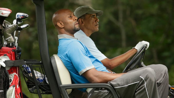 Former NBA player Alonzo Mourning and President Barack Obama ride in a golf cart while golfing at Farm Neck Golf Club, in Oak Bluffs, Mass.