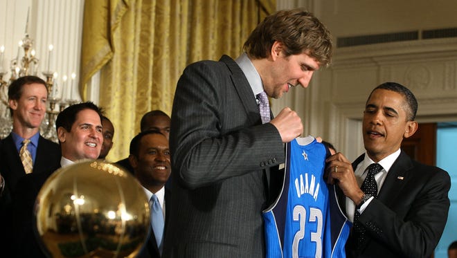 President Barack Obama is given a jersey from Dirk Nowitzki of the Dallas Mavericks during an event to honor the NBA champions in the East Room at the White House on January 9, 2012 in Washington, DC.