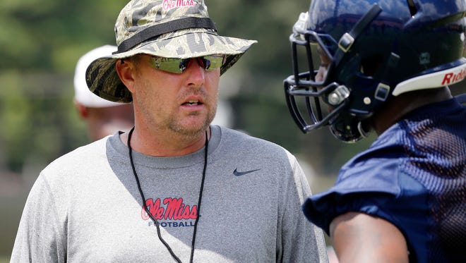 Mississippi football coach Hugh Freeze speaks with a player during an NCAA college football practice prior to media day activities, Monday, Aug. 8, 2016, in Oxford, Miss. (AP Photo/Rogelio V. Solis)