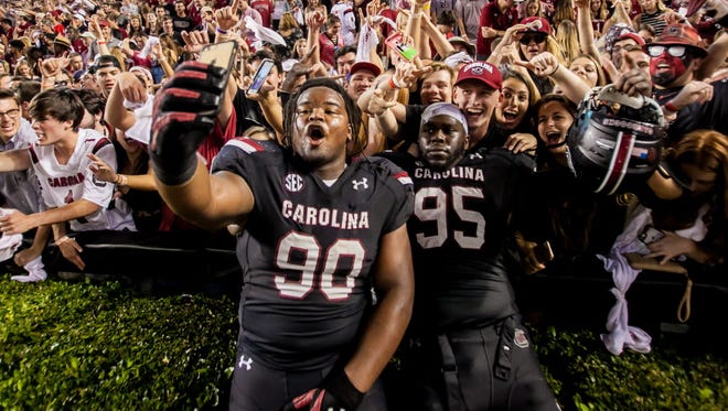 South Carolina defensive linemen Taylor Stallworth (90) and Dante Sawyer (95) take a selfie with the student section following the Gamecocks' win over Tennessee.