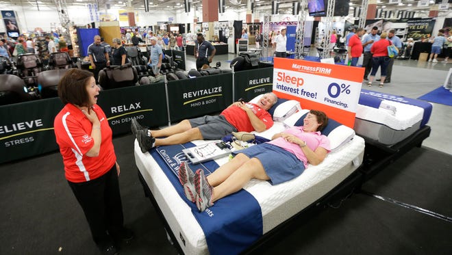 George and Jan Slupski, of Greendale try out a Chattam and Wells latex foam mattress at the Mattress Firm booth with help from Mattress Firm sales associate Joann Meehan at the exposition center.