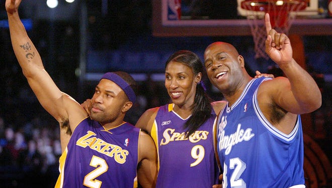 2004: Los Angeles Lakers Derek Fisher, left, Los Angeles Sparks Lisa Leslie, center, and Los Angeles Lakers Magic Johnson, pose for a photo after winning the "Shooting Stars" competition during the 2004 NBA All-Star festivities.