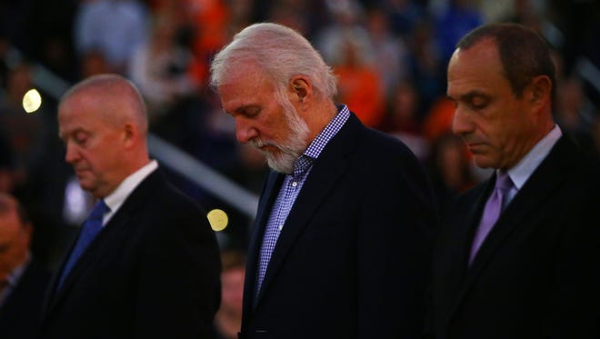 San Antonio Spurs head coach Gregg Popovich, center, reacts during a moment of silence honoring the memory of TNT announcer Craig Sager who died earlier today prior to the game against the Phoenix Suns at Talking Stick Resort Arena.