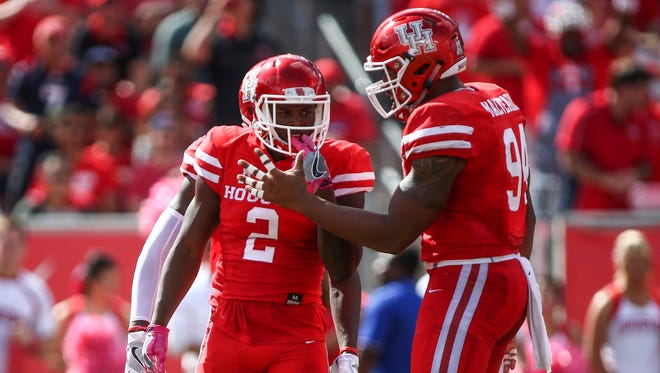 Houston Cougars safety Khalil Williams (2) celebrates with defensive end Cameron Malveaux (94) after a play during the second quarter against the Central Florida Knights at TDECU Stadium.