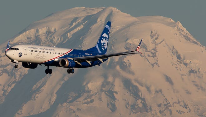 Alaska Airline's veterans-themed Boeing 737 passes in front of Mt. Rainier before landing at Seattle Tacoma International Airport in May 2017.