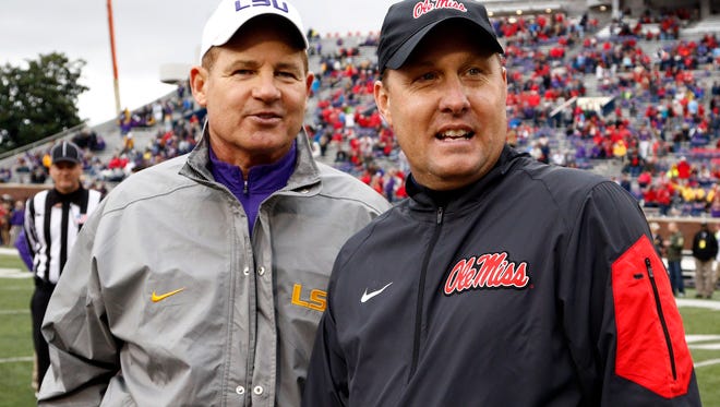 LSU head coach Les Miles, left, confers with Mississippi head coach Hugh Freeze before an NCAA college football game in Oxford, Miss., Saturday, Nov. 21, 2015. (AP Photo/Rogelio V. Solis)