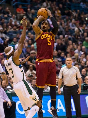Cavaliers guard J.R. Smith (5) shoots over the outstretched arm of Bucks guard Jason Terry during Tuesday's game.