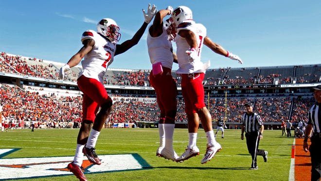 Louisville Cardinals wide receiver Reggie Bonnafon (7) celebrates with Cardinals wide receiver Jaylen Smith (9) and Cardinals wide receiver Jamari Staples (2) after catching a touchdown pass against the Virginia Cavaliers in the fourth quarter at Scott Stadium. The Cardinals won 32-25.