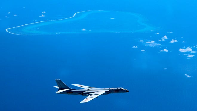 In this undated file photo released by Xinhua News Agency, a Chinese H-6K bomber patrols the islands and reefs in the South China Sea.