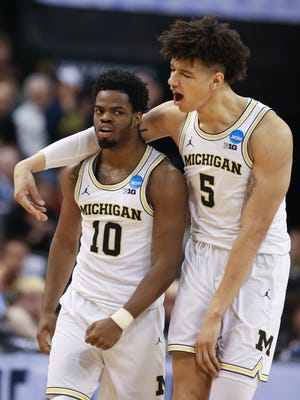 Michigan Wolverines Derrick Walton Jr., left, and D.J. Wilson celebrate a basket against Oklahoma State during the second half of U-M's 92-91 win Friday, March 17, 2017 at Bankers Life Fieldhouse in Indianapolis in the NCAA tournament.