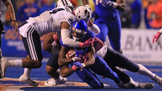 Boise State wide receiver Cedrick Wilson is tackled by BYU linebacker Fred Warner at Albertsons Stadium.