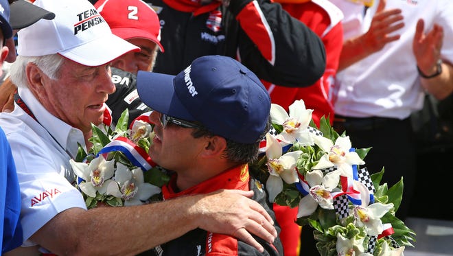 Roger Penske hugs IndyCar Series driver Juan Pablo Montoya as they celebrate in victory circle after winning the 2015 Indianapolis 500.