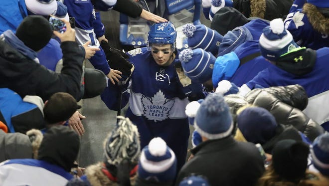 Maple Leafs center Auston Matthews (34) is congratulated by fans as he walks off the field after scoring the game-winning goal in overtime against the Red Wings during the Centennial Classic.
