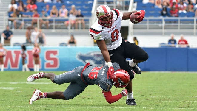 Western Kentucky running back Marcus Ward (8) is tackled by Florida Atlantic cornerback Chris Tooley (26) during the first half.