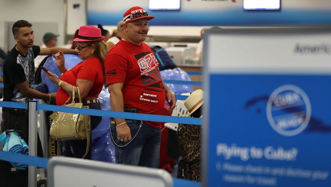 Juan Perez (right) and Onelia Martinez Castillo (pink hat) check in to their American Airlines Flight to Cuba which was the first commercial flight from Miami to Cuba in 55-years on Sept. 7, 2016.