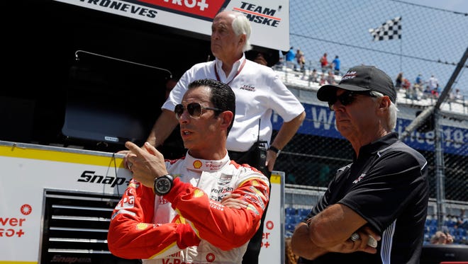 Helio Castroneves, front left, talks with four-time Indianapolis 500 champion Rick Mears, right, in front of car owner Roger Penske during practice for the Indianapolis 500 in 2015. Castroneves has won the race three times; Mears four.