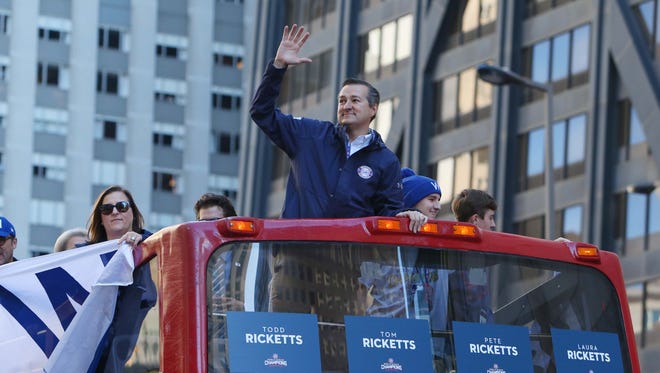 Cubs owner Tom Ricketts waves to the crowd during the parade on Michigan Avenue.