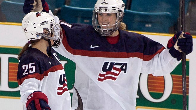 In this Nov. 4, 2014, file photo, Team United States' Monique Lamoureux, right, celebrates her goal against Team Finland with teammate Alex Carpenter at Four Nations Cup women's hockey tournament in Kamloops, British Columbia.